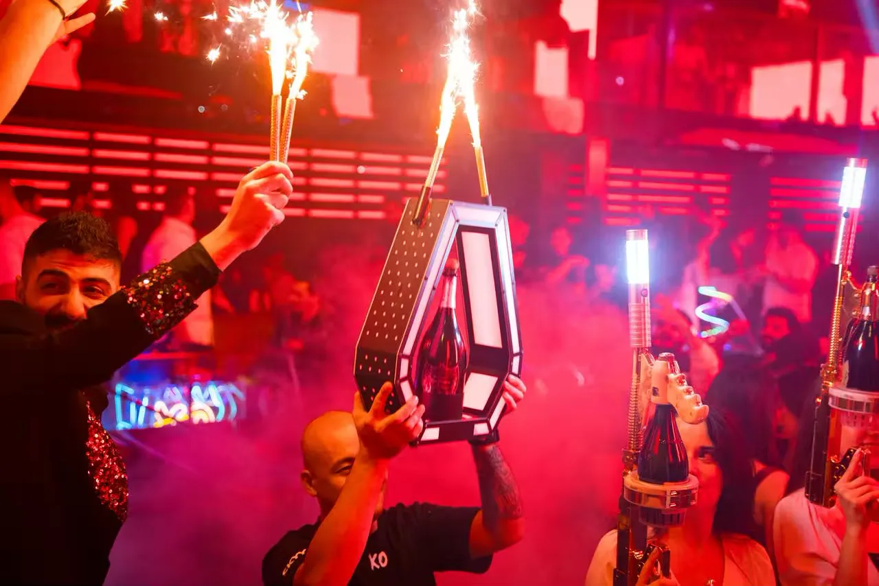 Guests seated at a VIP table in a modern Business Bay nightclub enjoying bottle service with ambient lounge lighting